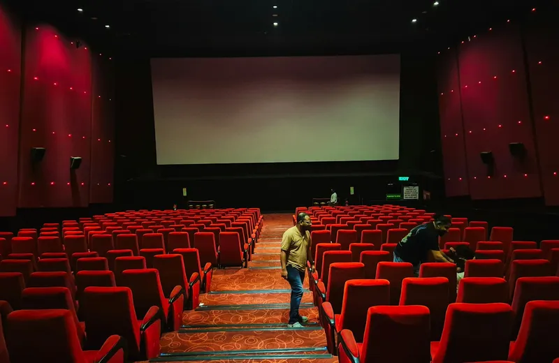 Cinema with rows of red seats in front of a large screen — ViviMate movies
